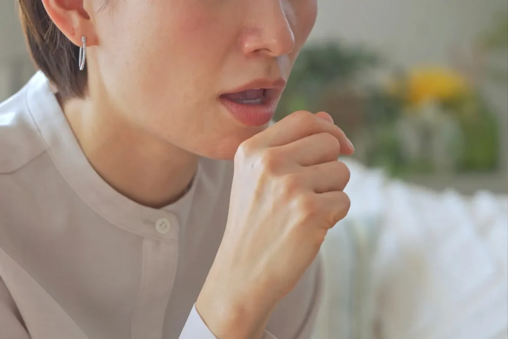 口の前に手をあて咳き込む様子