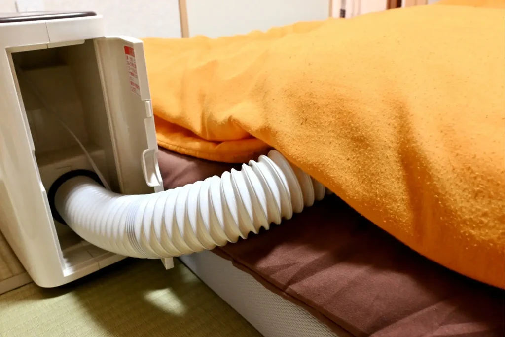 寝具の下に専用機械を挿入している様子
