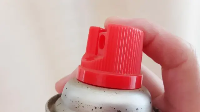 スプレーを持って噴射する構え